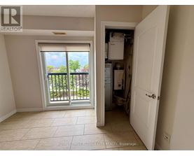 A room with a sliding glass door leading to a balcony and a kitchen area with a refrigerator, sink, and cabinets.