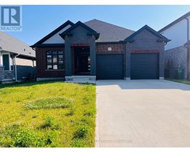 A house with a grey roof and a garage door is for sale.