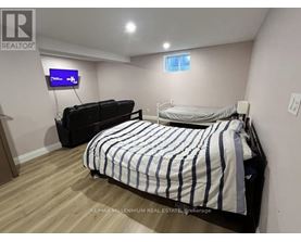 A bedroom with a bed, a couch, and a television.