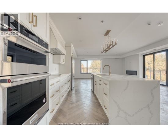 A kitchen with white cabinets and a marble countertop.
