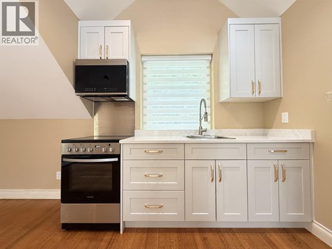 A modern kitchen with white cabinets and a stainless steel oven.