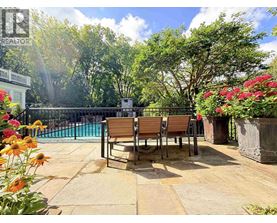 A pool surrounded by a wooden bench and concrete floor.