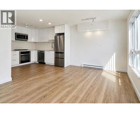 A spacious kitchen with wooden floors and stainless steel appliances.