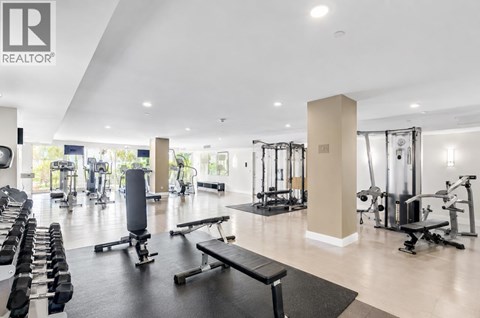 A gym with a variety of equipment including weights and cardio machines.