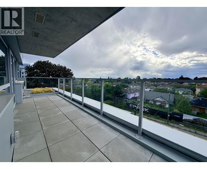 A balcony with a view of houses and trees.