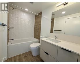 A white bathroom with a toilet, sink, and bathtub.