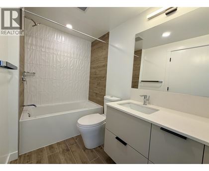 A white bathroom with a toilet, sink, and bathtub.