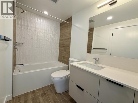A white bathroom with a toilet, sink, and bathtub.
