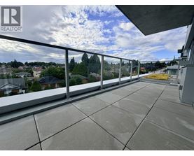A balcony with a metal railing and a view of houses and trees.