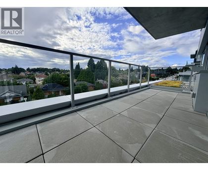 A balcony with a metal railing and a view of houses and trees.