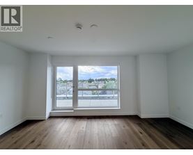 A large empty room with a window overlooking a cityscape.