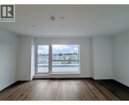 A large empty room with a window overlooking a cityscape.