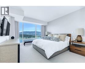 A bedroom with a large bed and a view of the mountains outside the window.