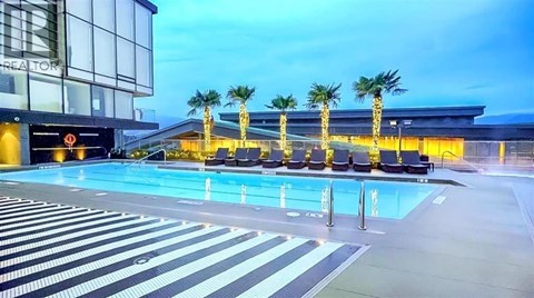 A pool area with palm trees and lounge chairs.