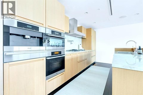 A modern kitchen with wooden cabinets and stainless steel appliances.
