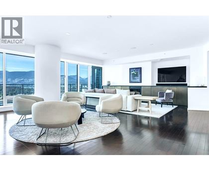 A living room with white furniture and a large window overlooking a snowy landscape.