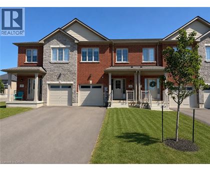 A large, two-story house with a garage and a driveway.
