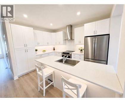 A modern kitchen with white cabinets and a stainless steel refrigerator.