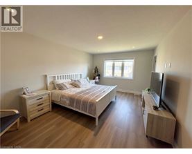 A bedroom with a bed, nightstand, and television.