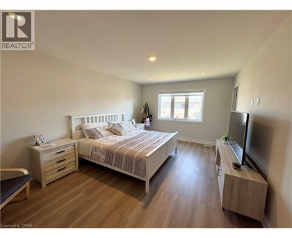 A bedroom with a bed, nightstand, and television.