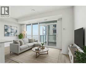 A living room with a grey couch, a coffee table, and a flat screen TV.