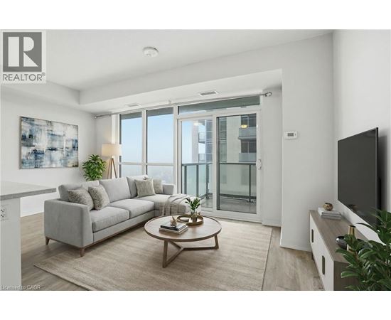 A living room with a grey couch, a coffee table, and a flat screen TV.