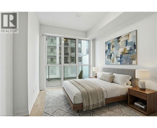 A bedroom with a large bed and a painting on the wall.