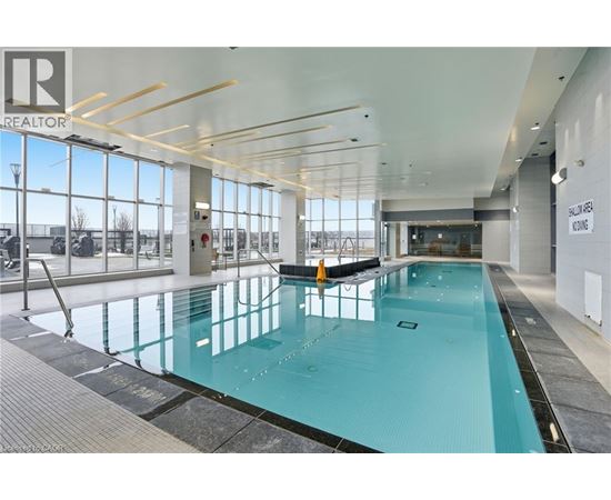 A large indoor swimming pool with a glass bottom.
