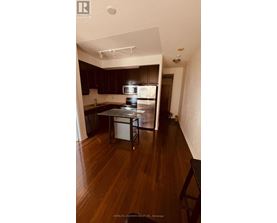 A kitchen with dark wood cabinets and a white fridge.