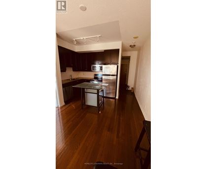 A kitchen with dark wood cabinets and a white fridge.