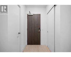 A hallway with a wooden door and white walls.