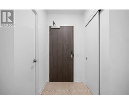 A hallway with a wooden door and white walls.