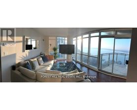 A living room with a couch and a television with a view of the ocean.