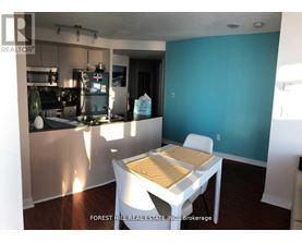 A kitchen with a table and chairs in the foreground and a blue wall in the background.