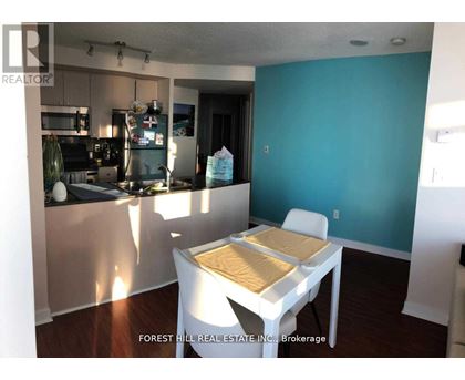 A kitchen with a table and chairs in the foreground and a blue wall in the background.