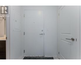 A white door with a handle and a small square on the wall.