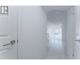 A white hallway with doors on either side and a logo in the top left corner.