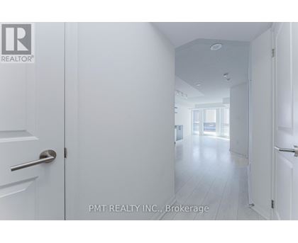 A white hallway with doors on either side and a logo in the top left corner.