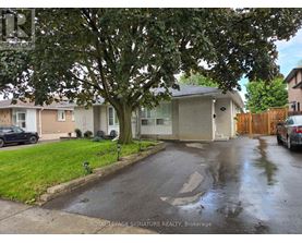 A wet residential street with a Royal LePage Signature Realty Brokerage sign.