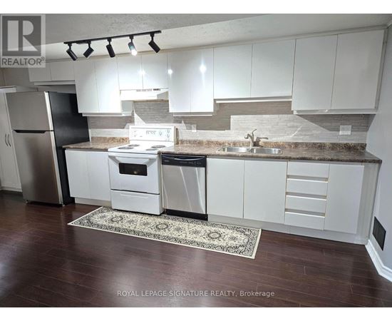 A kitchen with white cabinets and a black refrigerator.