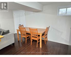 A dining room with a wooden table and chairs.