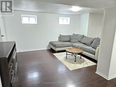 A living room with a grey couch and a wooden coffee table.
