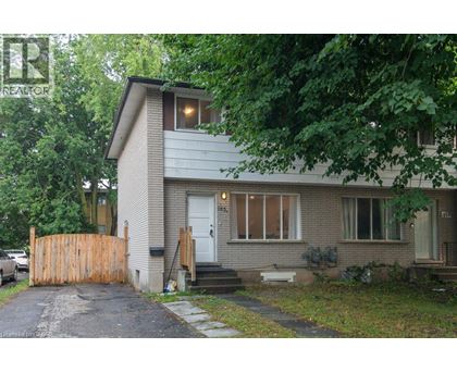 A house with a grey roof and a white door is surrounded by trees.