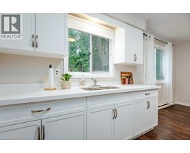 A white kitchen with a sink and cabinets.