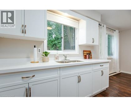 A white kitchen with a sink and cabinets.
