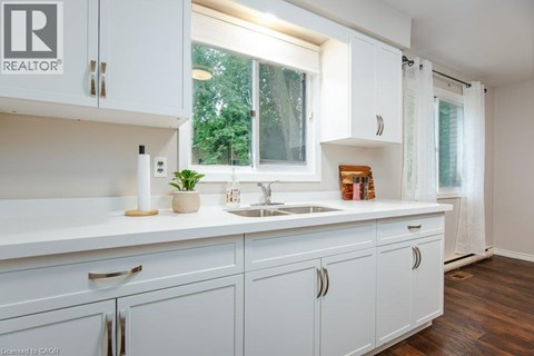 A white kitchen with a sink and cabinets.