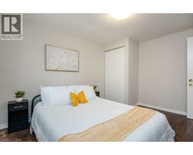 A bedroom with a white bed and a yellow throw blanket.