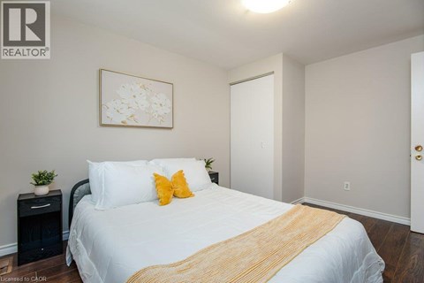 A bedroom with a white bed and a yellow throw blanket.