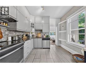 A modern kitchen with grey cabinets and a wooden floor.