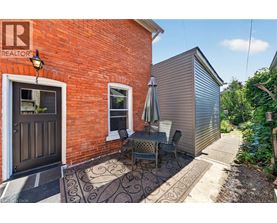 A patio with a table and chairs is in front of a red brick building.